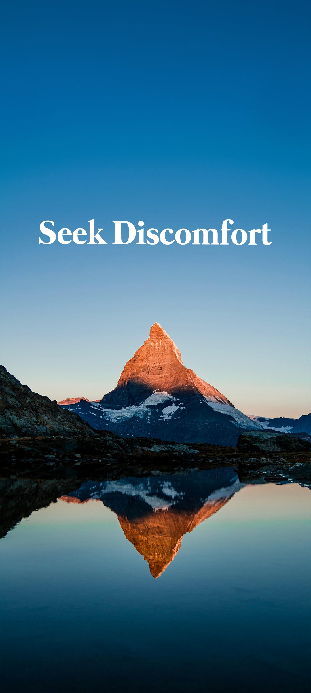 Mountain peak reflected in water with 'Seek Discomfort' text on a blue background